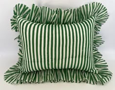 two green and white striped pillows stacked on top of each other with ruffled edges