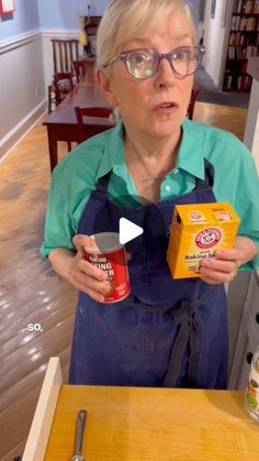 an older woman holding two cans of food