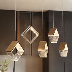 four hanging lights in the shape of squares and rectangles on a kitchen counter