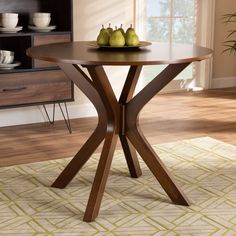 a wooden table with two pears on it in front of a bookcase and window