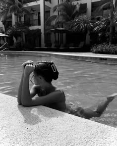 a woman in a swimming pool with her hand on her head