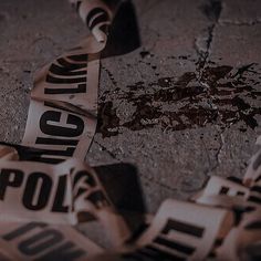 several pieces of torn newspaper sitting on top of a cement floor with the word police taped to it