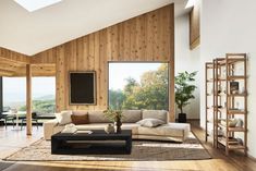 a living room with wood paneling and large windows