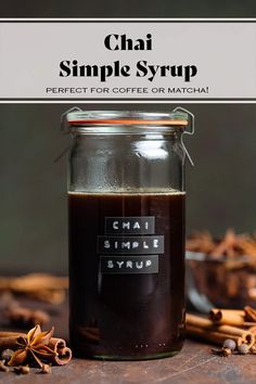 a glass jar filled with coffee sitting on top of a table next to cinnamons