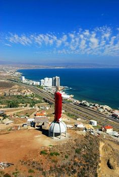 a large statue on top of a hill next to the ocean