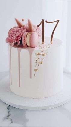 a white cake with pink and gold decorations