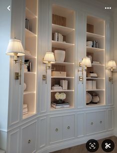 a large white bookcase with two lamps on each side