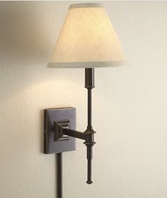 a lamp on the wall with a white shade