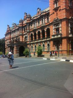 an old building with people walking in front of it