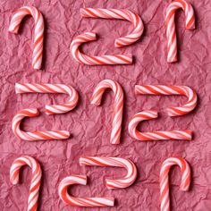 candy canes are arranged in the shape of numbers on a piece of pink paper