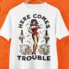 For those who like tattoos or for friends who do this traditional old-school design is a must have. Here Comes Trouble a Sailor Jerry vibe is printed on Comfort Colors t shirts which are my personal favorites. This makes a wonderful gift for Christmas, birthdays, as a stocking stuffer or for a Secret Santa gift.  Comfort Colors introduces its garment-dyed t-shirt; a fully customizable tee made 100% with ring-spun cotton. The soft-washed, garment-dyed fabric brings extra coziness to your wardrobe Trouble Tattoo, Tattoo Shirt Design, Here Comes Trouble, Tattoo Shirt, Tattoo Shirts, Tattoo T Shirts, Sailor Jerry, School Tattoo, Concert Shirts