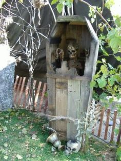 an outhouse with skulls in the yard