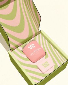 an open pink and green box with some kind of item in it's lid