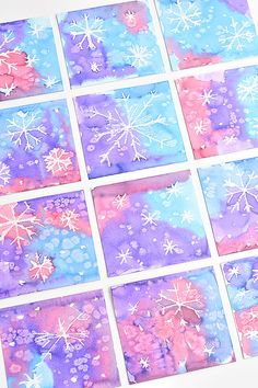 paper snowflakes are arranged on top of purple and blue papers with white dots