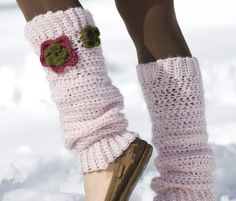 a woman's legs wearing pink knitted socks with flower decorations on them in the snow