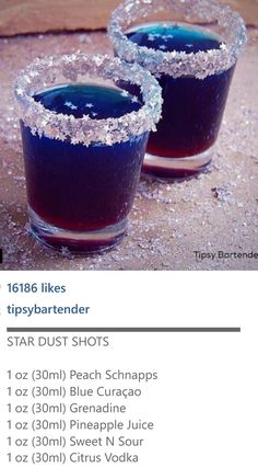 two glasses filled with blue liquid sitting on top of a table next to each other