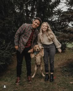 a man and woman standing next to a dog