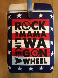 a cooler with the words rock mama and wagon on it's side sitting on top of a wooden floor