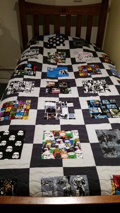 a bed with a black and white checkered bedspread that has pictures on it