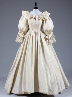 an antique dress with ruffled sleeves and collared neckline, on display at the museum