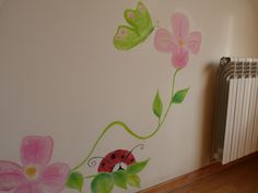 a painted wall with flowers and a ladybug on it