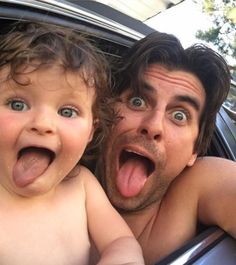 a man and child sticking their tongues out in the back of a car