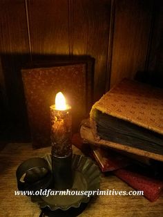 a lit candle sitting on top of a table next to some books and other items