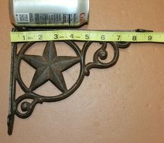 a metal star with a measuring tape on top of it next to a bottle opener