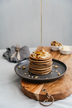 a stack of pancakes sitting on top of a black plate