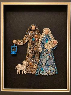 two beaded figurines are in a shadow box