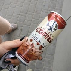 a woman holding up a can of coffee