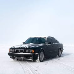 a black car is parked in the snow