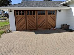 a white house with two brown garage doors