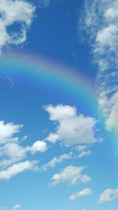 a rainbow in the sky with clouds above it