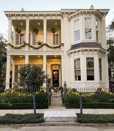 a large white house with christmas decorations on it's windows and balconies