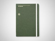 a green notebook sitting on top of a white table