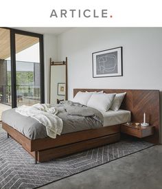 a bedroom with a large bed and sliding glass doors leading to an outside deck area