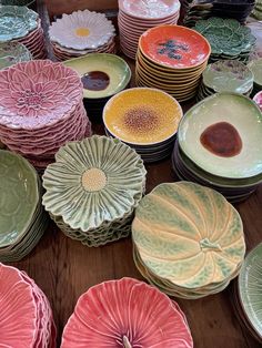 many different colored plates on a wooden table