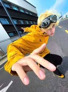 a young boy wearing goggles and pointing at the camera with his hand in front of him