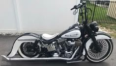 a white and black motorcycle parked next to a fence