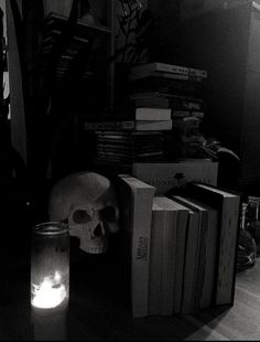 a table topped with books and a lit candle next to a pile of stacked books