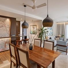 the dining room table is surrounded by modern chairs and art on the wall behind it