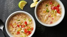 two bowls filled with soup next to a spoon