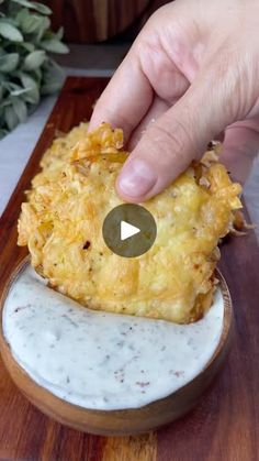 a person is dipping some food into a bowl