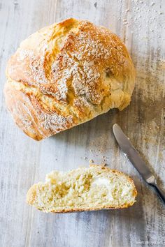 a loaf of bread sitting on top of a wooden cutting board next to a knife