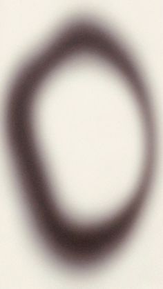 a blurry image of a circular object on a white surface with black circles in the middle