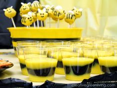 a table topped with cups filled with yellow liquid and smiley faces on top of them