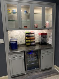 a kitchen with gray cabinets and white tile backsplash, including an open refrigerator