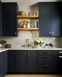 a kitchen with dark blue cabinets and white counter tops is seen in this image from the front view