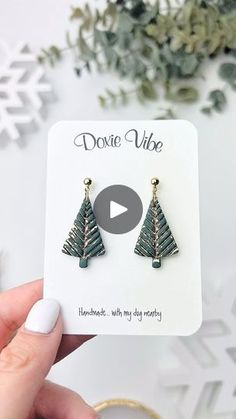 a pair of christmas tree earrings on top of a card